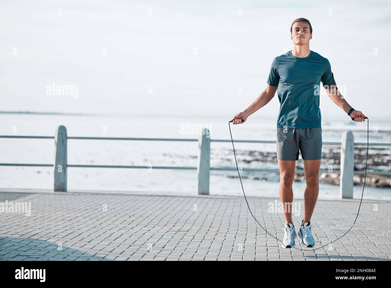 Saltar cuerda, maqueta y hombre de entrenamiento en la playa para su  ejercicio al aire libre por la mañana, entrenamiento y rutina de fitness.  Atleta, cardio y salto masculino Fotografía de stock -