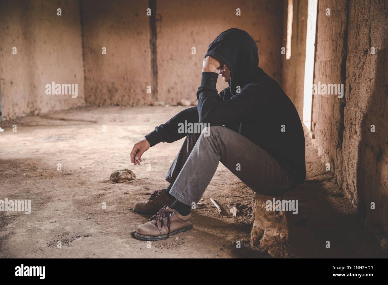 Hombres que muestran estrés y soledad, hombre sin hogar adicto a drogas sentado solo y deprimido en una casa sintiéndose ansioso y solitario, lo social Fotografía de stock - Alamy
