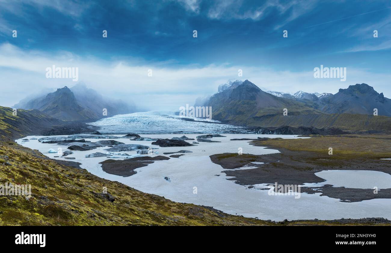 La lengua del glaciar se desliza desde el icecap de Vatnajokull o el glaciar Vatna cerca del volcán subglaciar Oaefajokull, Islandia. Laguna glacial con bloques de hielo y su Foto de stock