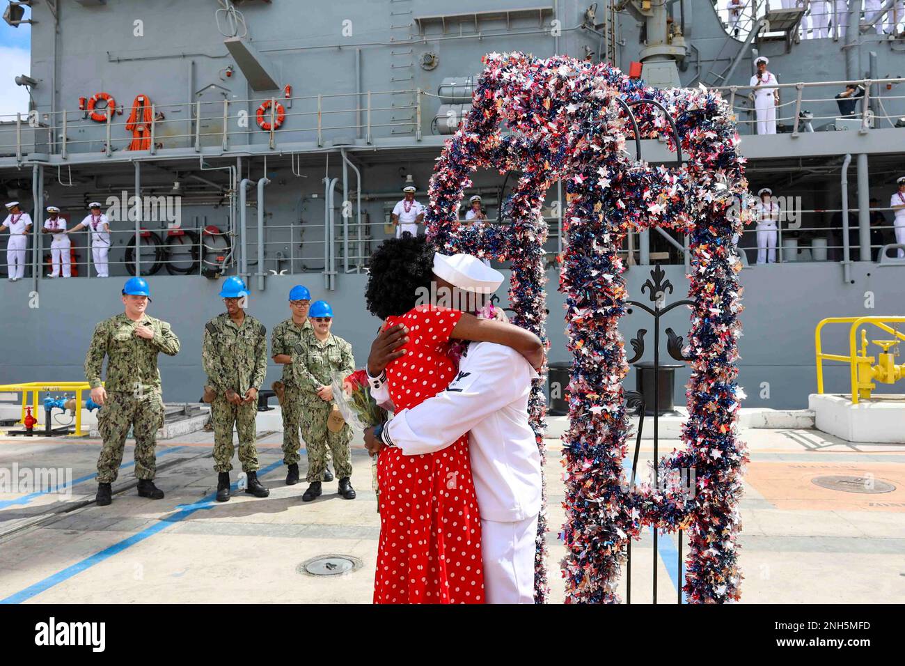 220718-N-RB283-0014 USS Port Royal (CG-73) regreso a casa después de ser desplegado desde enero de 2022. Las familias dieron la bienvenida a los marineros con carteles y abrazos en la Base Conjunta Pearl Harbor-Hickam, Hawái, 14 de julio de 2022. Foto de stock