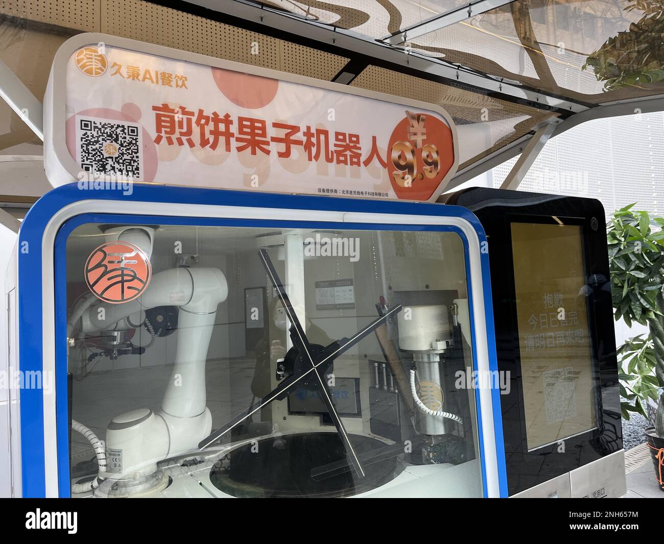 Un robot para hacer guozi jianbing, una especie de panqueque relleno,  aparece a la salida de la estación de metro de Niujie, atrayendo a muchos  ciudadanos a la experiencia, Beijing, China, 19