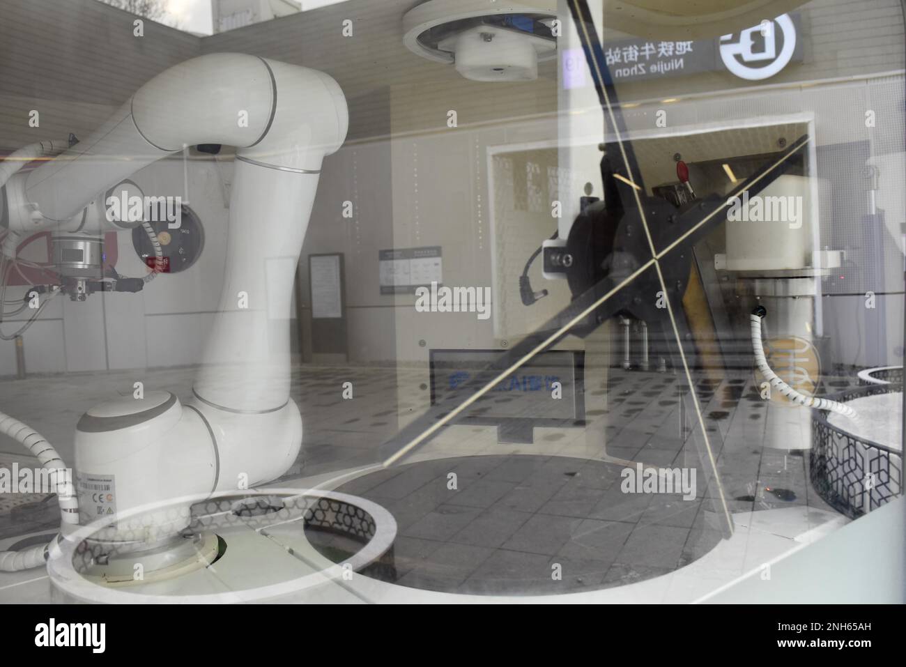 Un robot para hacer guozi jianbing, una especie de panqueque relleno,  aparece a la salida de la estación de metro de Niujie, atrayendo a muchos  ciudadanos a la experiencia, Beijing, China, 19