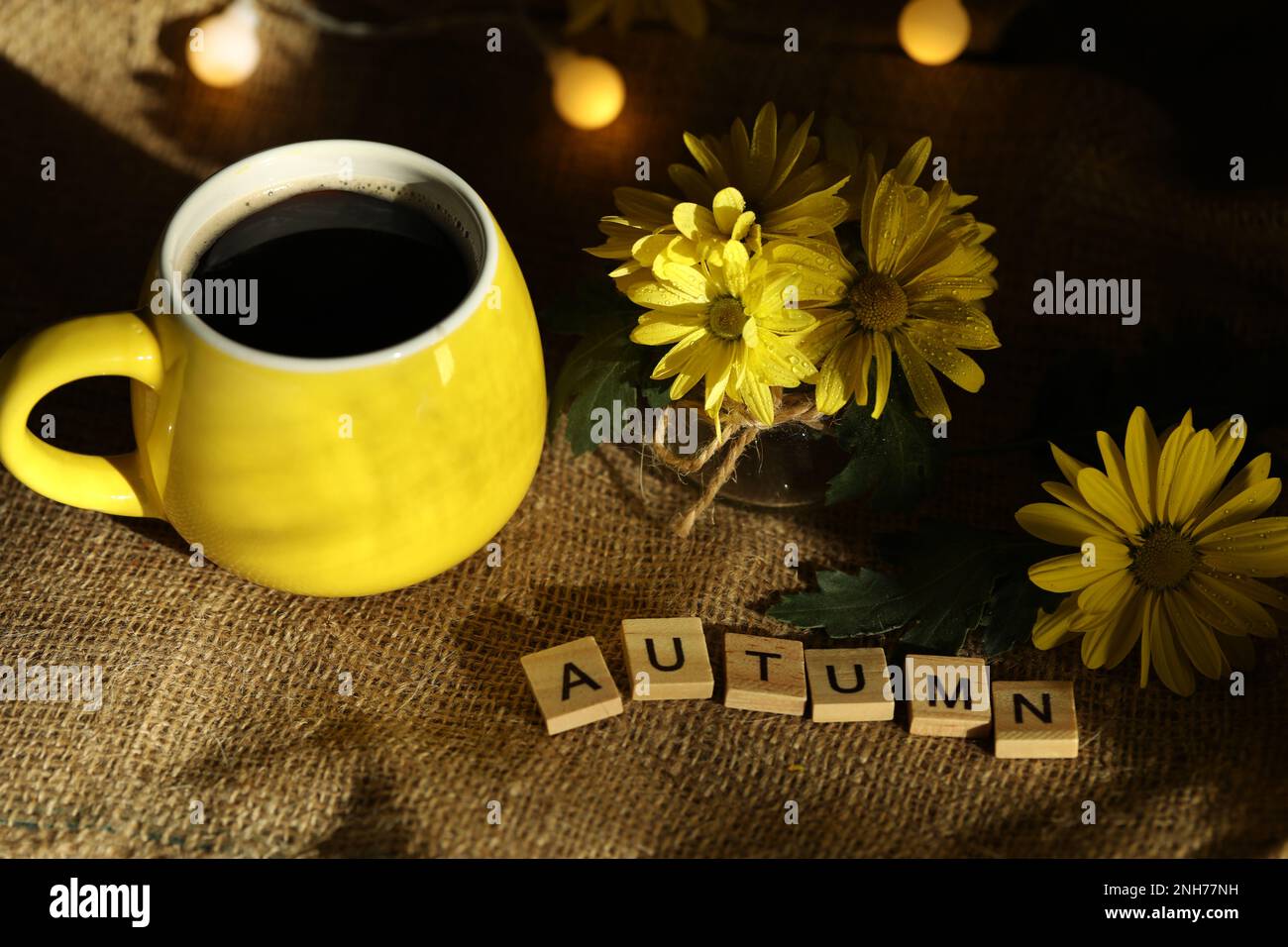 taza de café en el fondo de otoño con hojas y flores. Texto Otoño Foto de stock