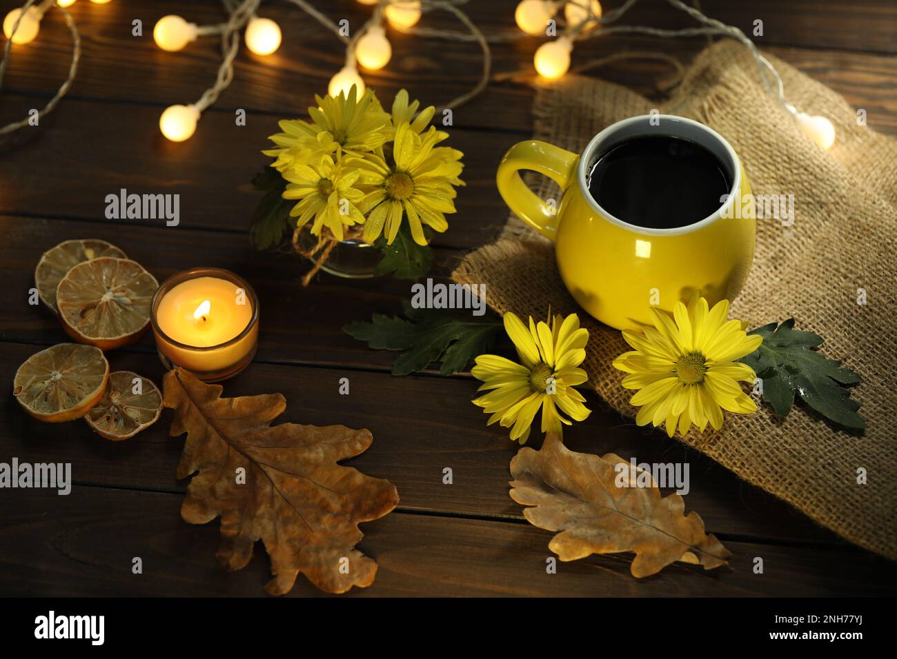 taza de café en el fondo de otoño con hojas y flores Foto de stock