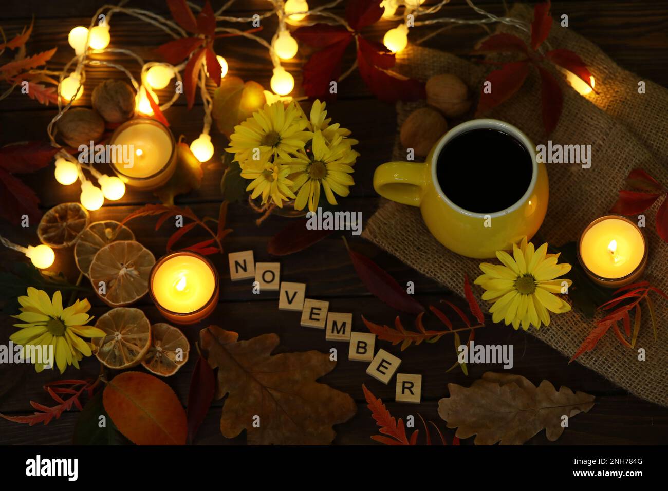 taza de café en el fondo de otoño con hojas y flores. Texto de noviembre Foto de stock