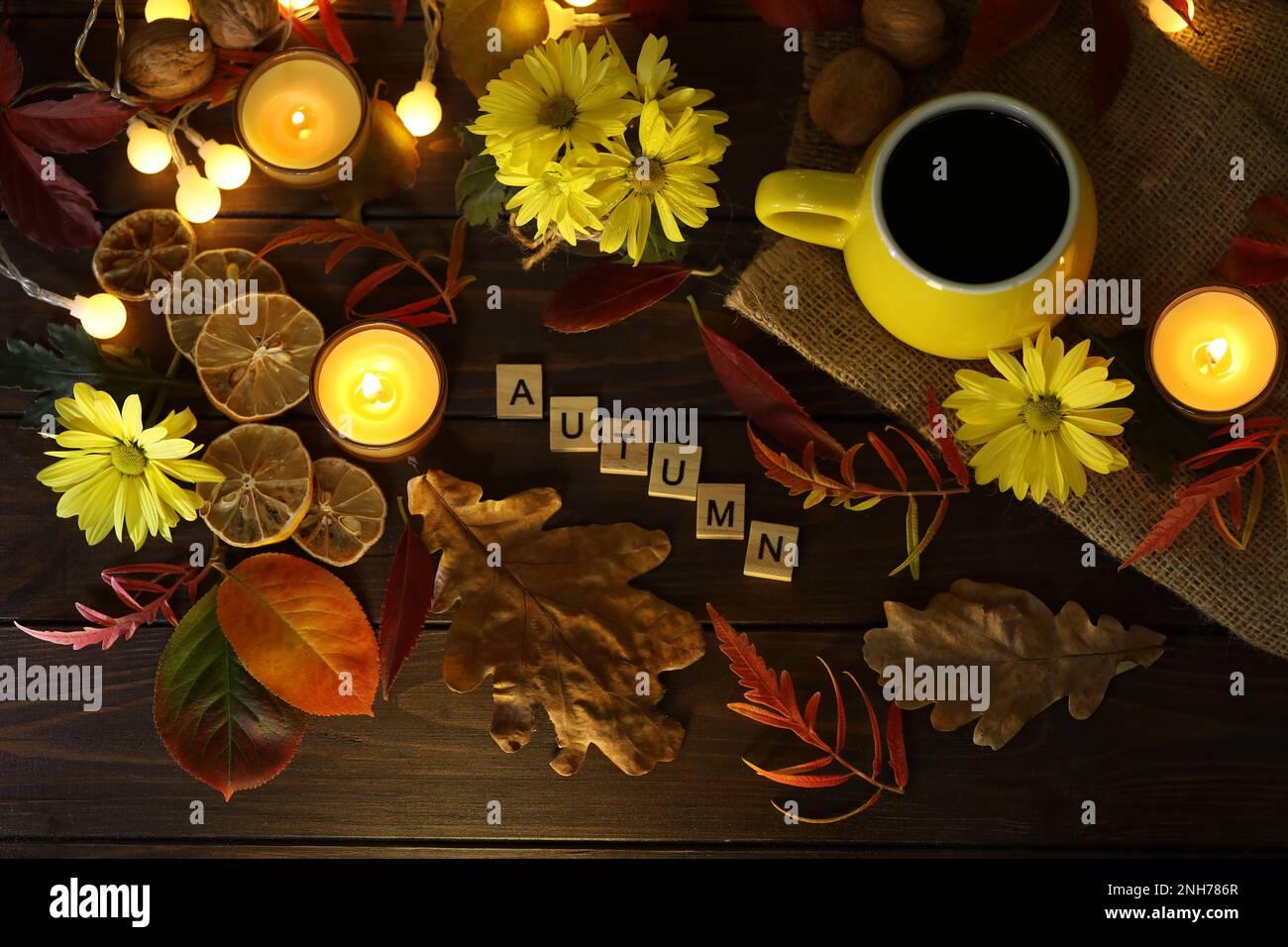taza de café en el fondo de otoño con hojas y flores. Texto Otoño Foto de stock