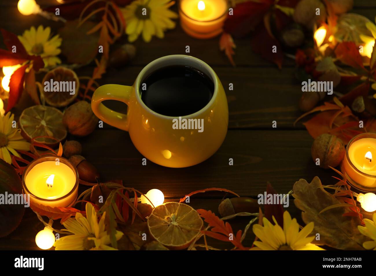 taza de café en el fondo de otoño con hojas y flores Foto de stock