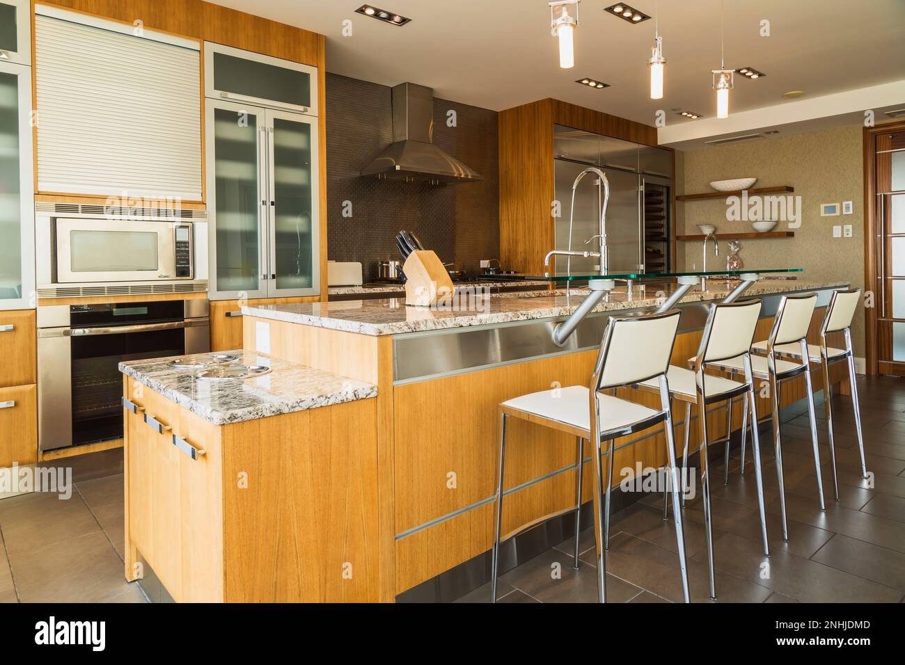 Gabinetes de madera y vidrio e isla con encimera de granito con matices