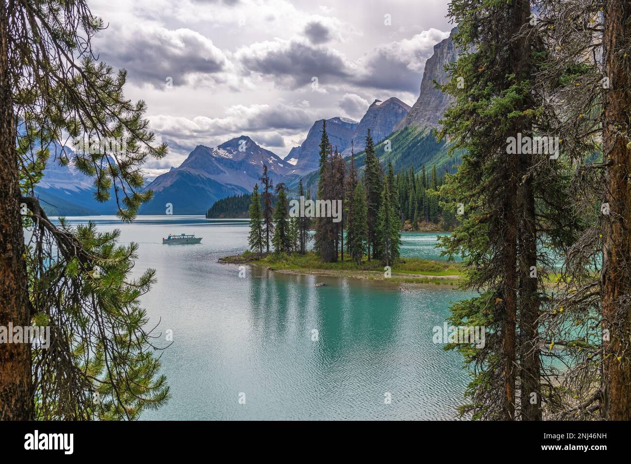 Isla del Espíritu con barco de excursión en el lago Maligne, Jasper, Canadá. Foto de stock