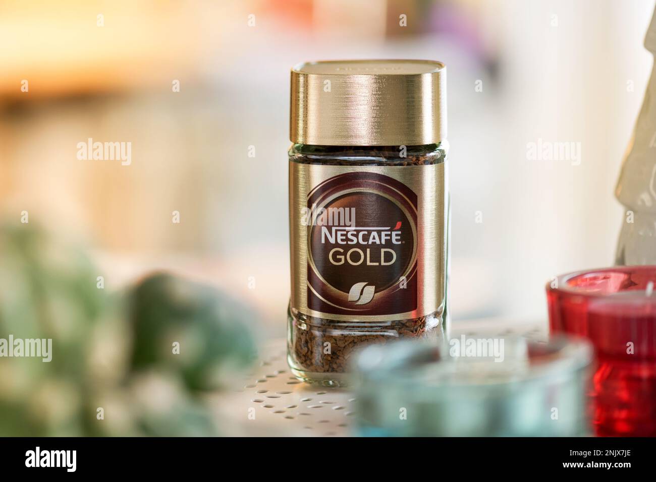 Tarro de cristal de café Nescafe colocado en la mesa contra el fondo borroso de la cocina. Producto Nestlé Foto de stock