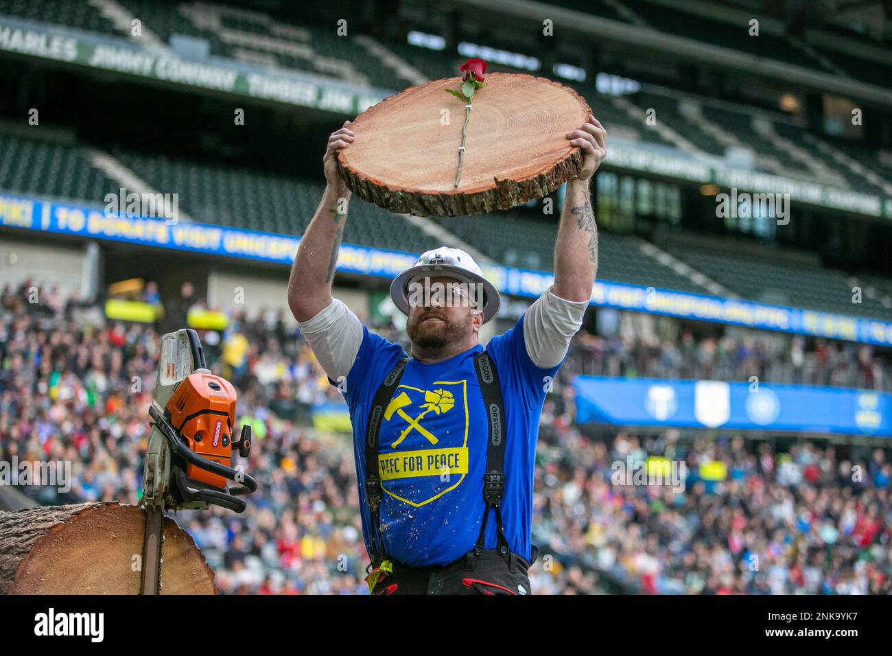 Timber Joey hoists a slab with a rose attached following a goal during