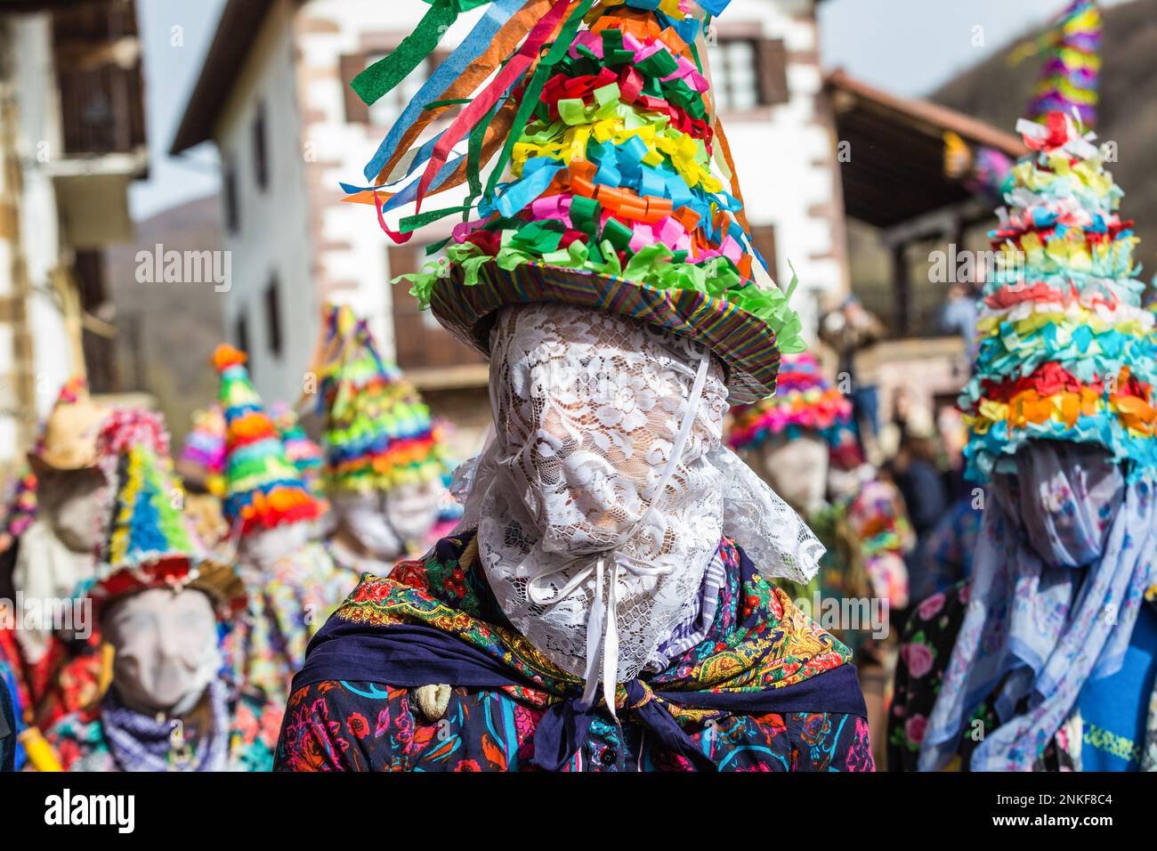 Máscara y gorro de un Txatxo, un personaje que representa a la población de  Lantz, mientras otros bailan alrededor del malvado bandido Miel Otxin. El  Carnaval Rural de Lanz, es una fiesta