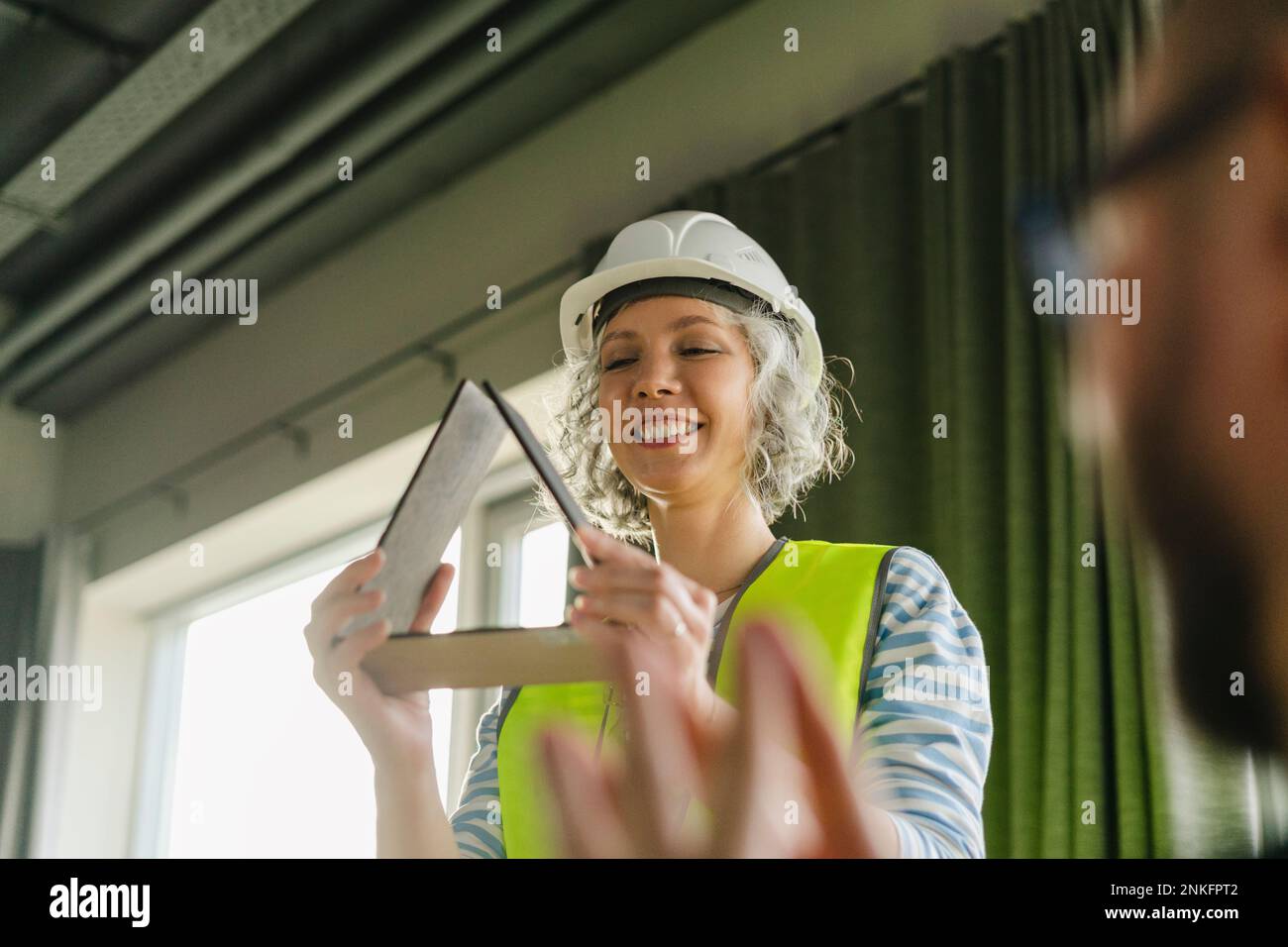 Ingeniero sonriente que sostiene el modelo de la casa en la oficina Foto de stock