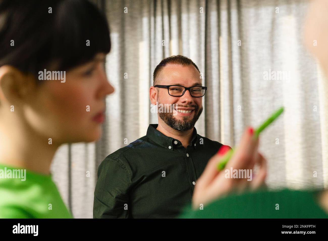 Empresario sonriente con su colega en la oficina Foto de stock