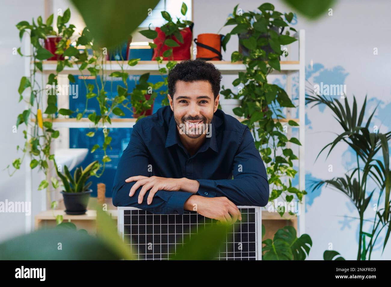 Retrato de hombre de negocios en oficina apoyado en el panel solar Foto de stock