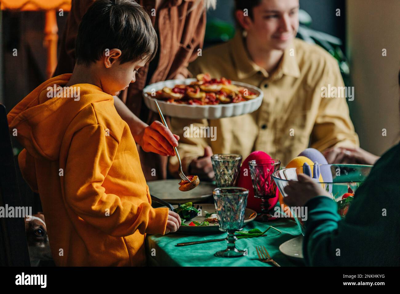 Muchacho con la familia que tiene la cena de Pascua en casa Foto de stock
