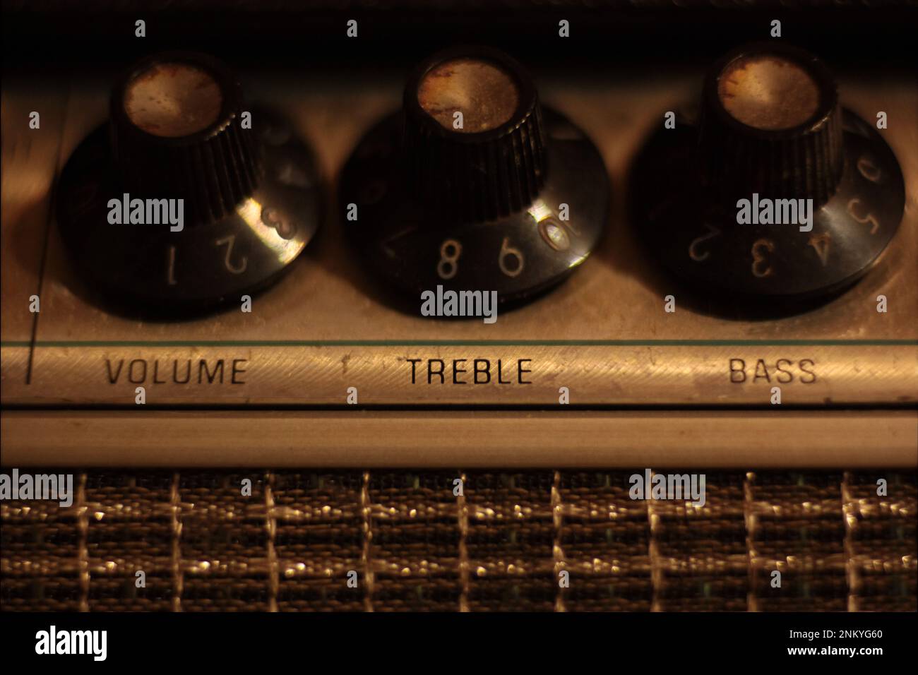 Agudos, volumen y bajos controles en la cabeza de amplificador de guitarra vintage 1960s. Temperatura de color cálido, profundidad de campo poco profunda, macro. Foto de stock