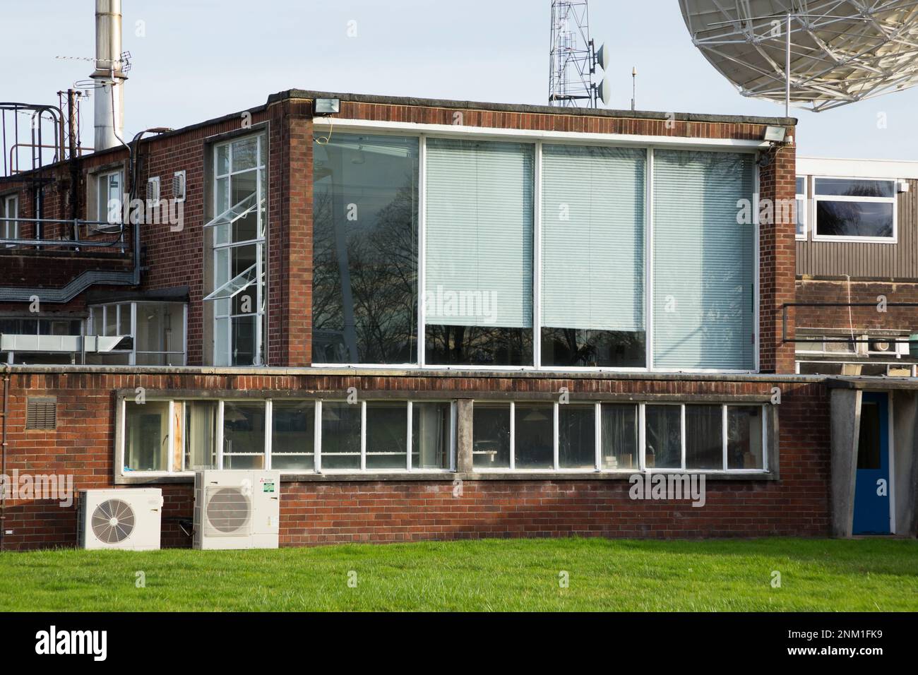 La sala de control (con las grandes ventanas protegidas por persianas) del gigantesco radiotelescopio Lovell – ignorado por el Telescopio de 7M / 7 metros. Sitio de Jodrell Bank, Cheshire, Reino Unido. (133) Foto de stock