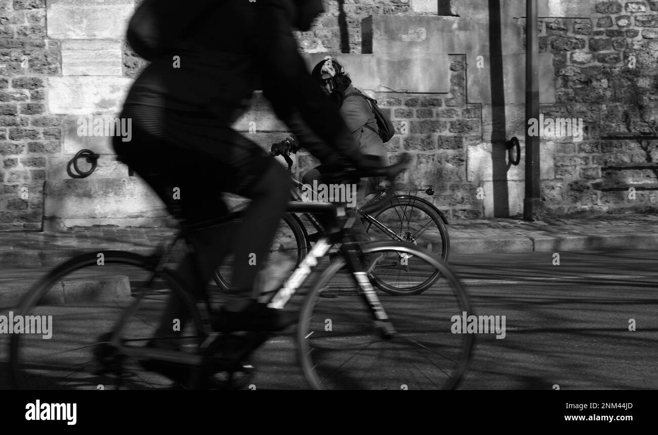 Vista monocroma de dos ciclistas que cabalgan A lo largo de las orillas del río Sena, París Francia Foto de stock