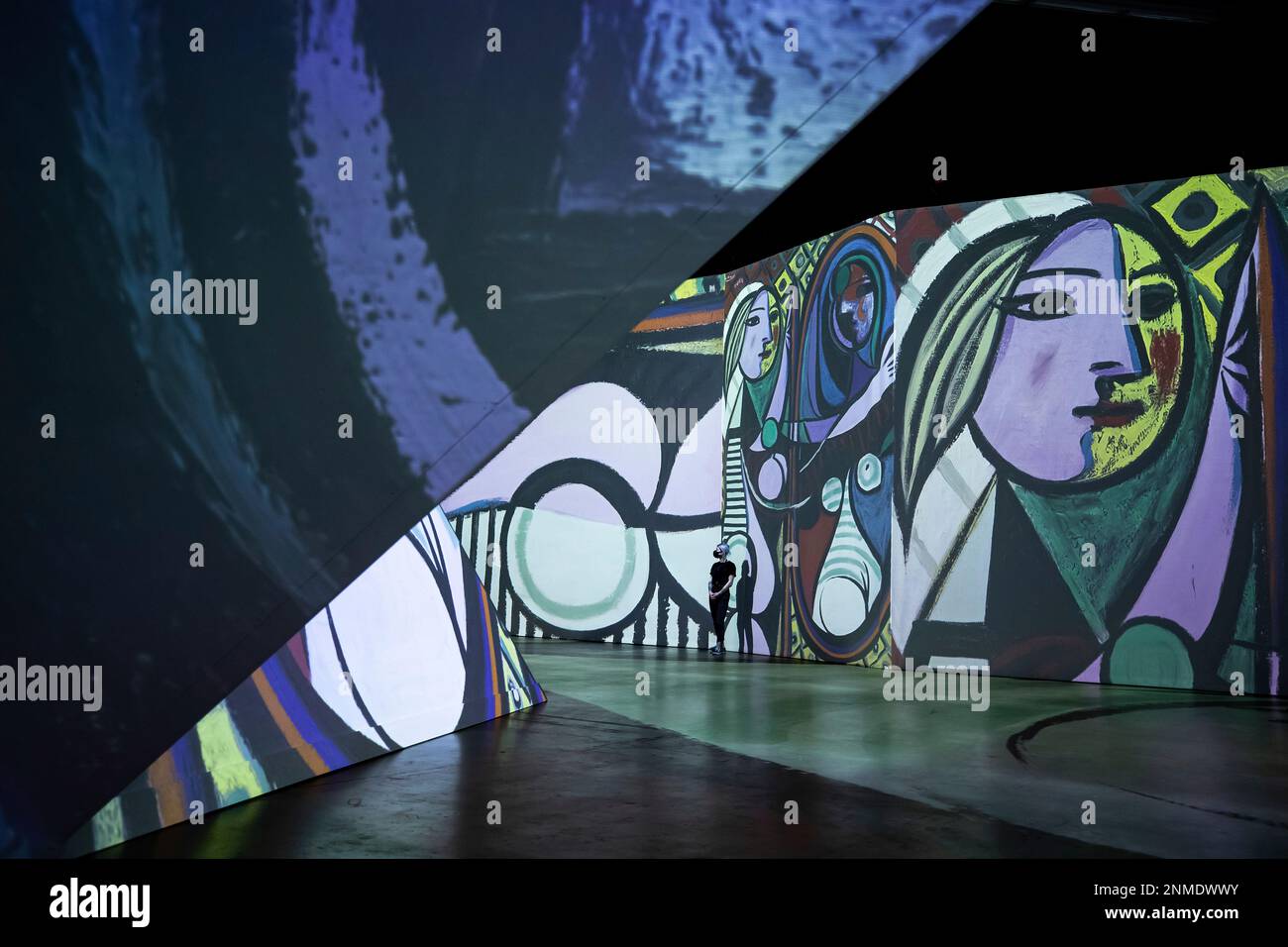 A staff member watches a preview of the Imagine Picasso immersive