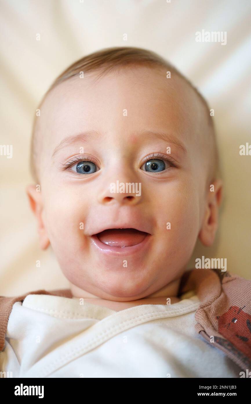 Retrato de un feliz sonriente bebé de ojos azules Foto de stock