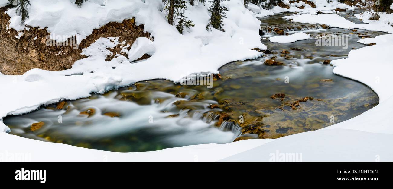 Bryant Creek que fluye a través del paisaje nevado, Canmore, Alberta, Canadá Foto de stock