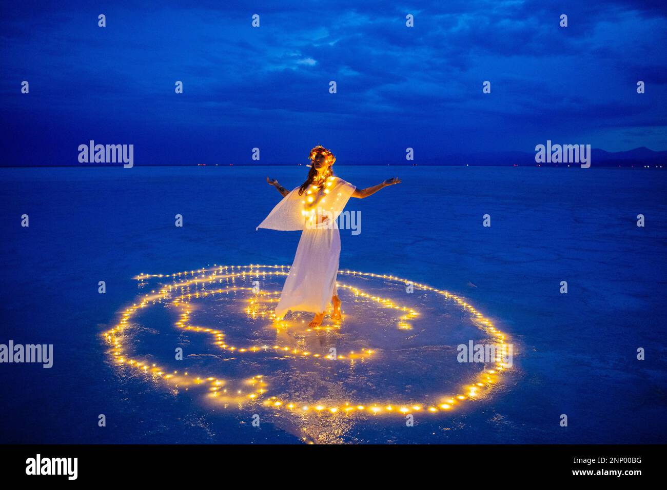 Bailarina femenina rodeada de círculo de luz sobre el agua Foto de stock