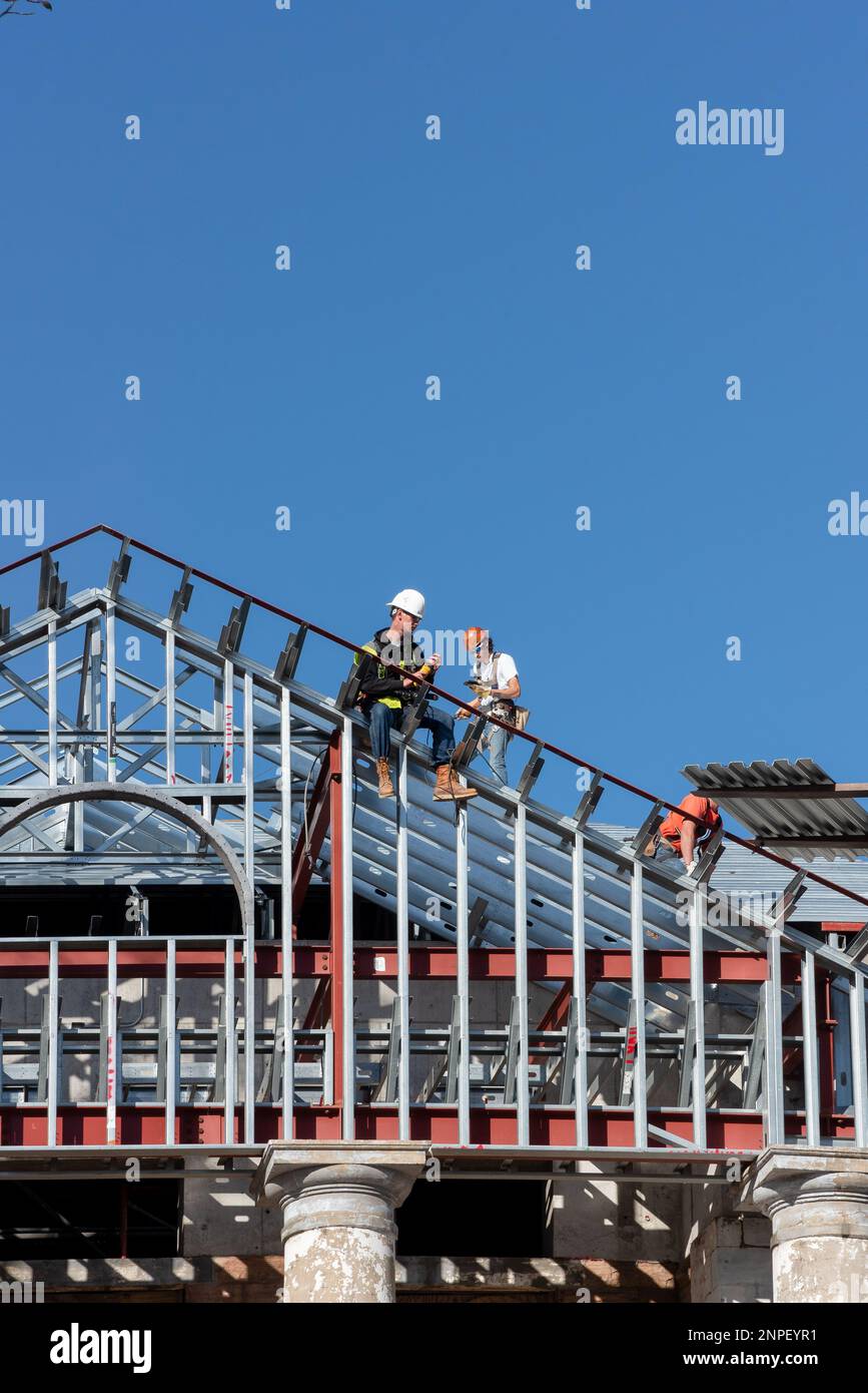 Dos trabajadores de la construcción se sientan en vigas que son el marco para el techo del Palacio de Justicia del Condado de Mason, Mason, Texas, Estados Unidos, EE.UU. Foto de stock