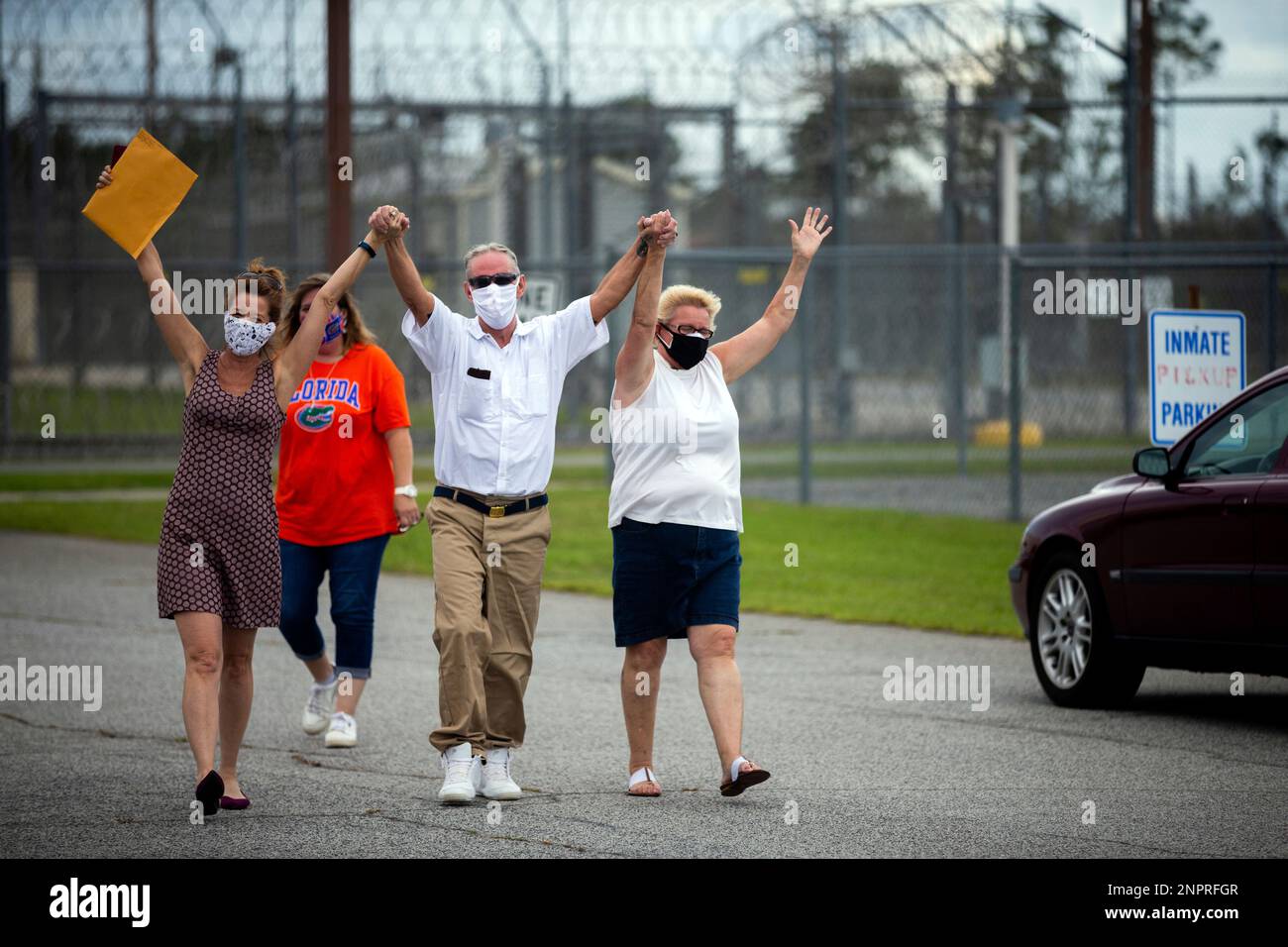 Dennis Perry, center, celebrates with, Suzanna Baugh, left, and his