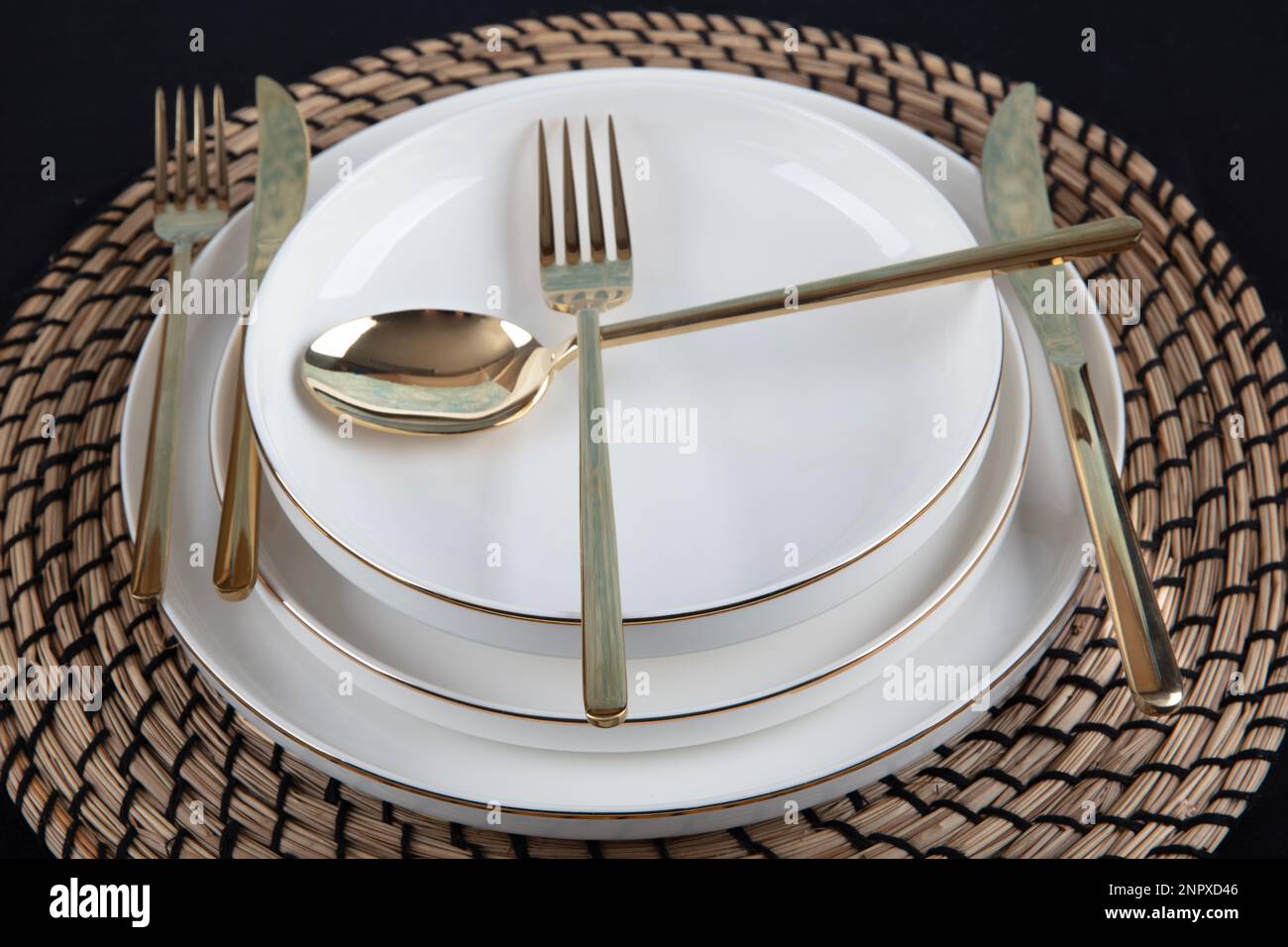 Platos y utensilios, plato, cuenco y cubiertos de oro contra el fondo de la mesa  de comedor, vista lateral. Vajilla de cerámica artesanal moderna Fotografía  de stock - Alamy