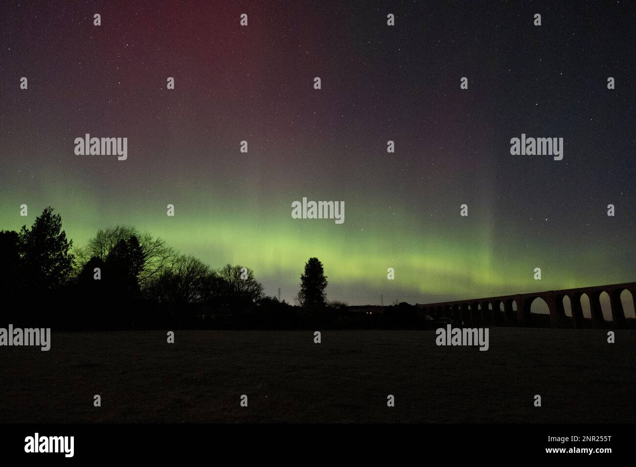 La Aurora Boreal (aurora boreal) ilumina el cielo sobre el viaducto de Culloden, cerca de Inverness en las tierras altas de Escocia. Foto de stock