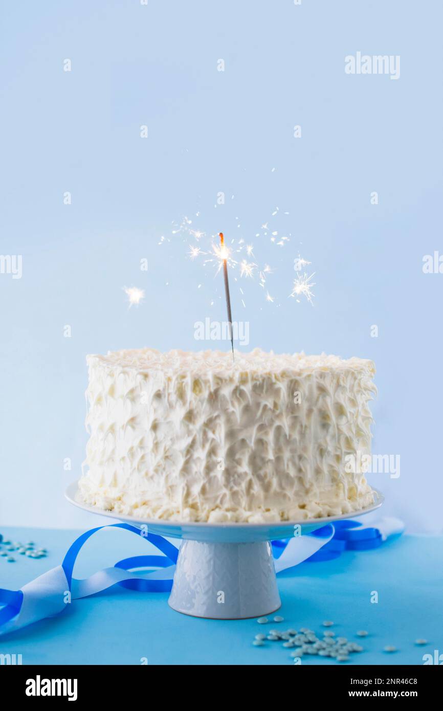 pastel de cumpleaños blanco con chispas ardientes. Foto de alta