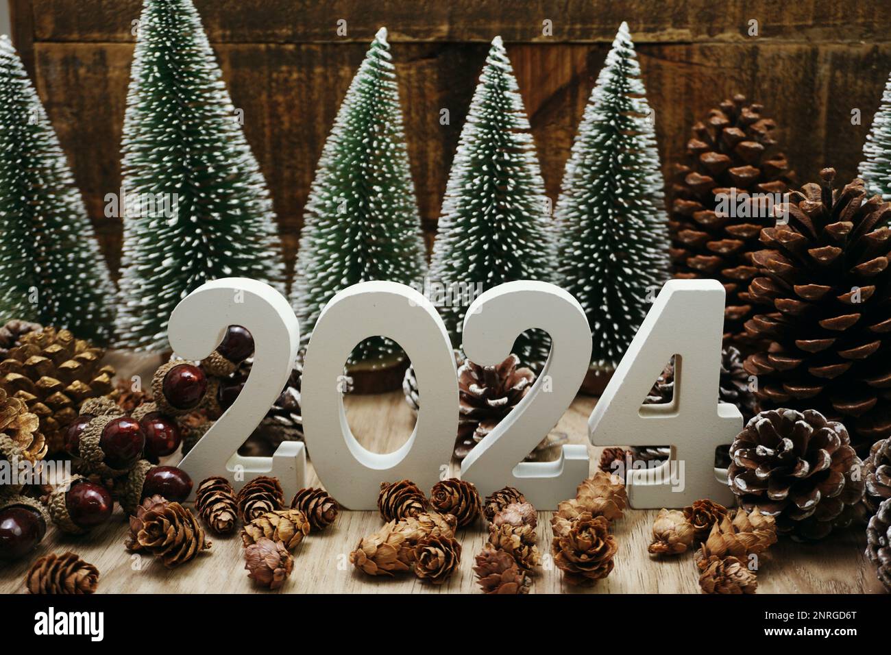 Feliz año nuevo 2024 decoración con árbol de Navidad y conos de pino sobre  fondo de madera Fotografía de stock - Alamy
