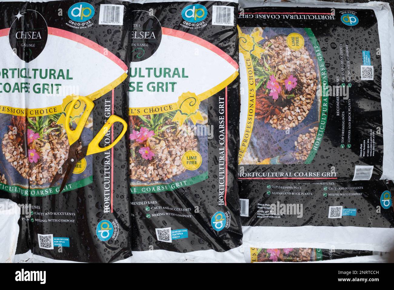 Una pila de bolsas de grano grueso hortícola para la siembra de vasijas superiores y la mejora del drenaje en suelos pesados, para la venta en un centro de jardín Foto de stock
