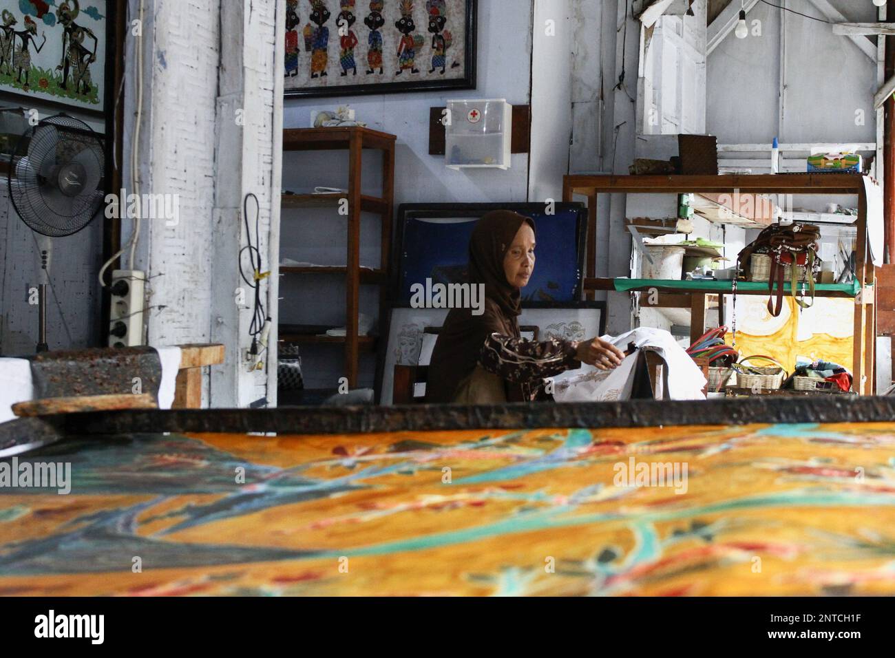 Yogyakarta, Indonesia. 27th de febrero de 2023. Un artesano trabaja en un  batik dibujado a mano para una decoración de pared en la Galería Batik  Seno, Yogyakarta. Los batiks decorativos se venden