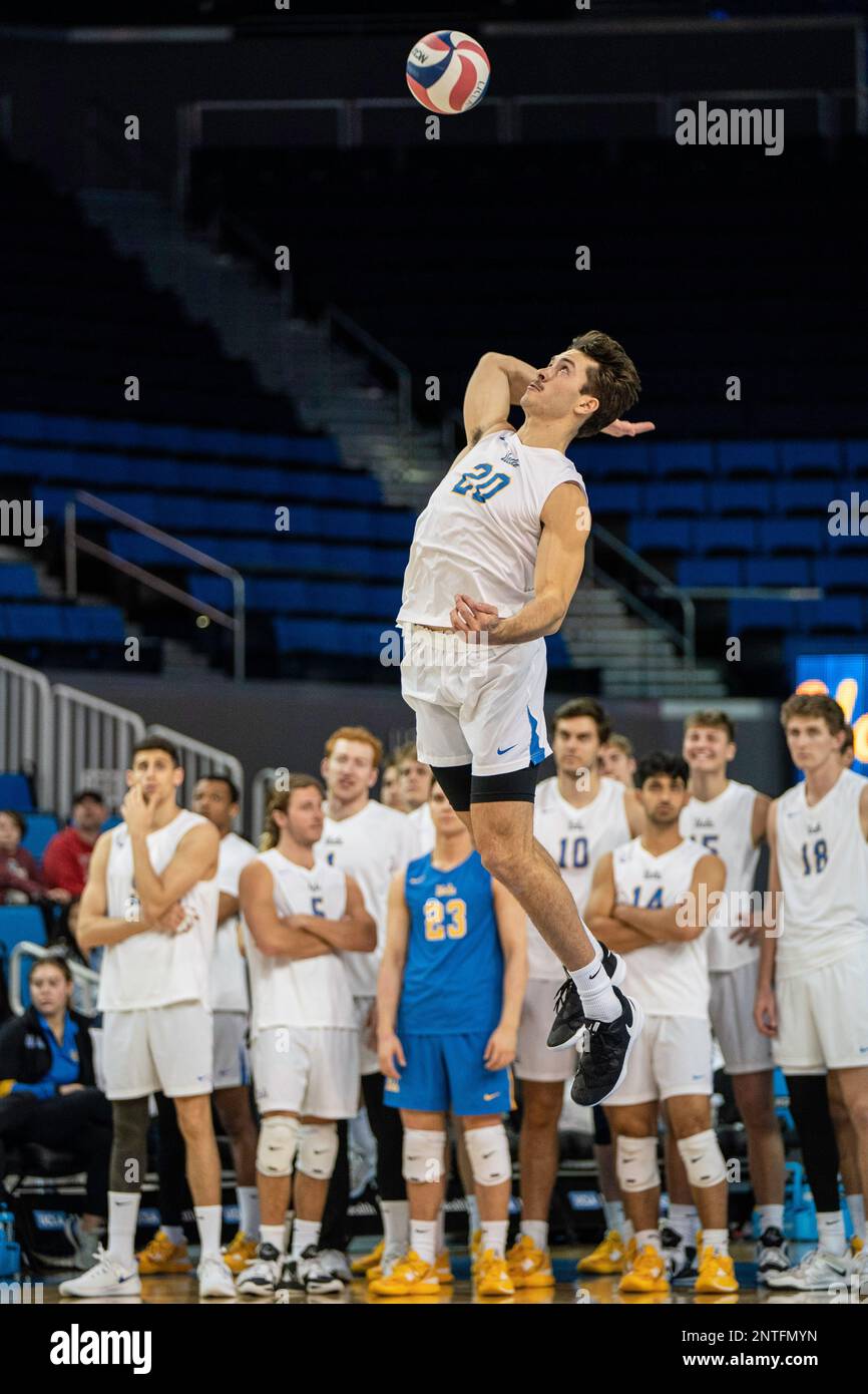 El bateador externo de los Bruins de la UCLA Ethan Champlin (20) sirve durante un partido de voleibol de la NCAA contra los osos hormigueros de la UCI, el sábado 26 de febrero de 2023, en Pauley Pav Foto de stock