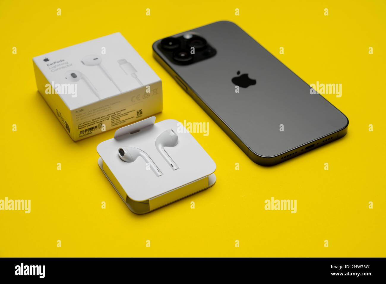 Nuevo iPhone 14 pro max y Apple EarPods, auriculares AirPods blancos para  escuchar música y podcasts en una caja abierta. Fondo amarillo aislado.  Budap Fotografía de stock - Alamy