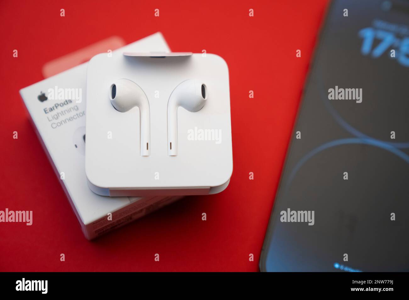 Nuevo iPhone 14 pro max y Apple EarPods, auriculares AirPods blancos para  escuchar música y podcasts en una caja abierta. Fondo rojo aislado.  Budapest Fotografía de stock - Alamy