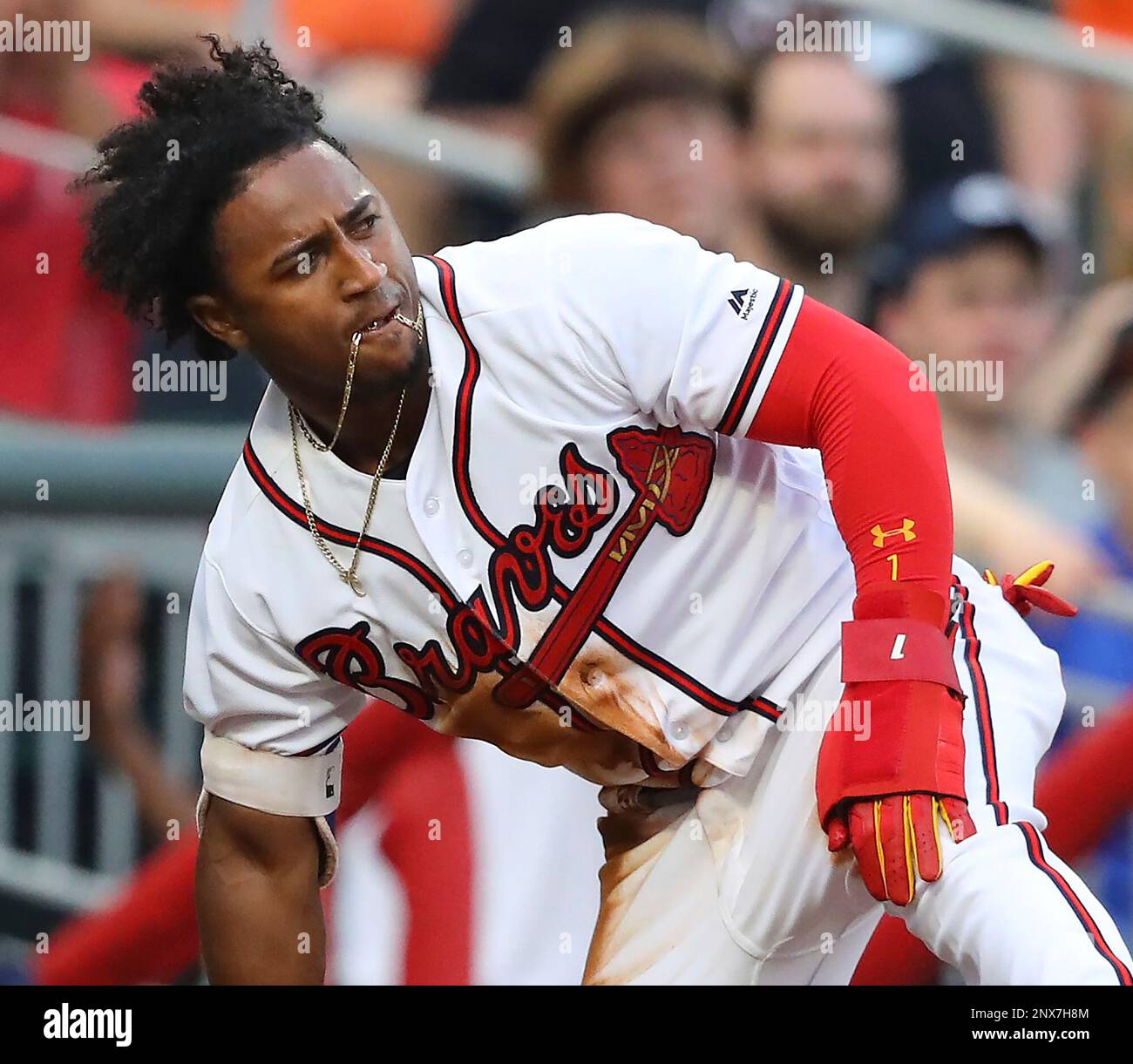 Atlanta Braves' Ozzie Albies has his chain in his teeth after
