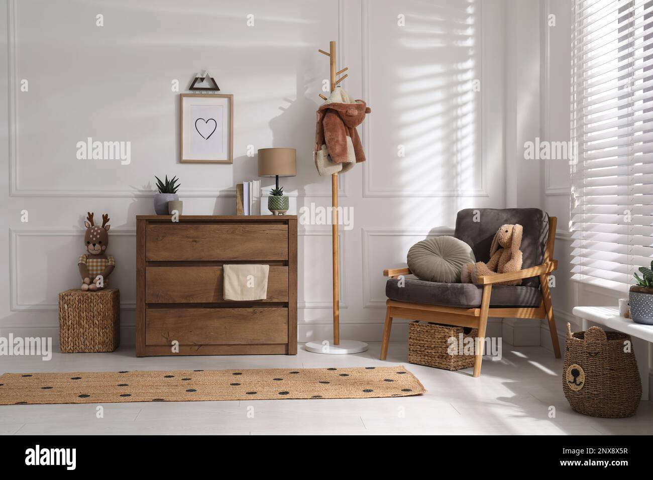 Elegante interior de la habitación con cómoda cajonera de madera y cómodo  sillón Fotografía de stock - Alamy