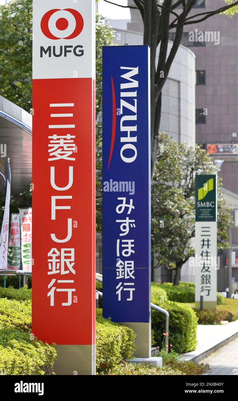 A picture taken on April 1, 2018 shows signboards of (L to R) MUFG Bank