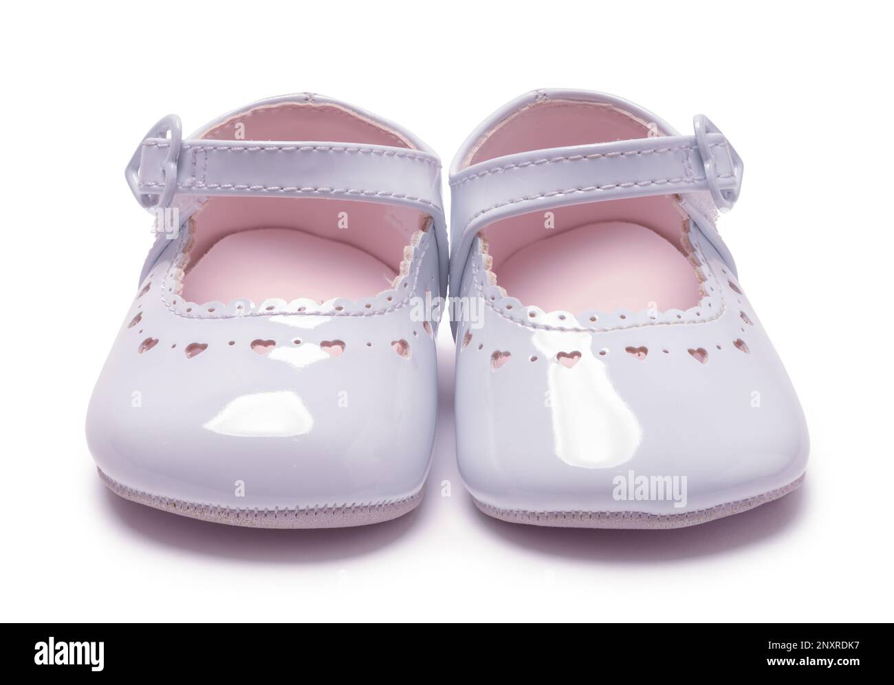 Par de zapatos de bebé de la muchacha cortado en blanco vista frontal. Foto de stock