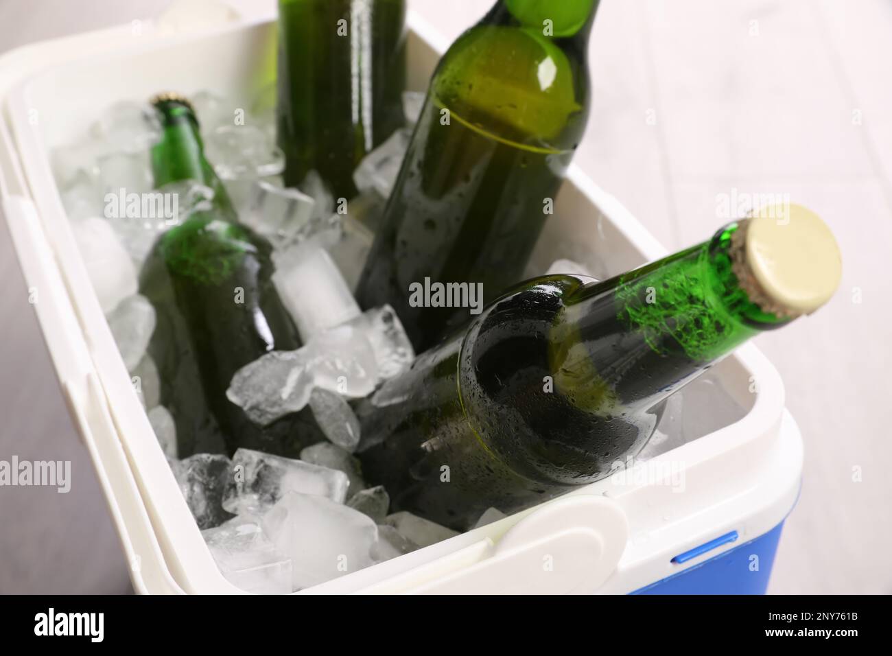 Caja fría de plástico con cubitos de hielo y cerveza, primer plano Foto de stock