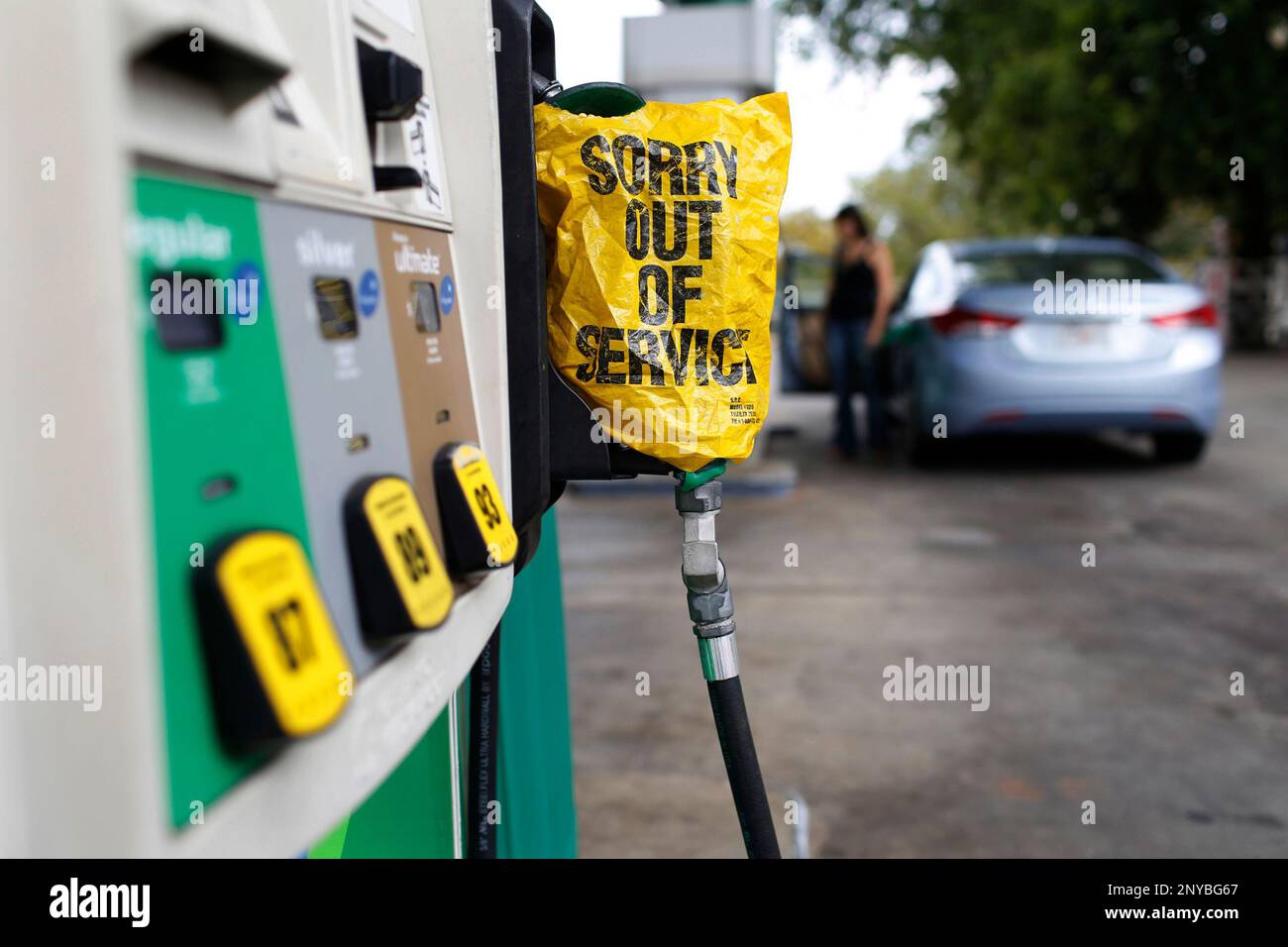 A "Sorry out of Service" sign is placed on one of the gas pumps at a