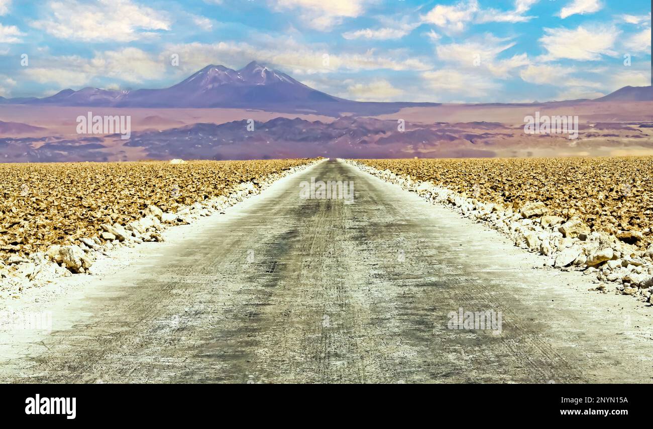 Paisaje desértico con camino blanco recto vacío a través de salar seco y árido, montañas borrosas - Salar de Atacama, Chile Foto de stock