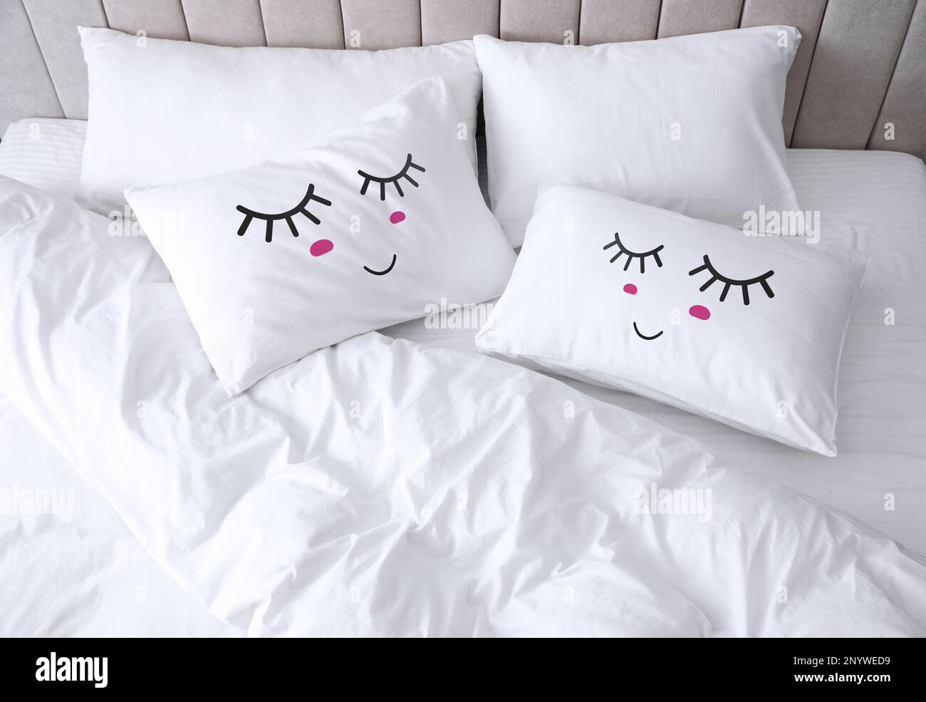 Almohadas suaves con caras lindas en una cama cómoda, por encima de la  vista Fotografía de stock - Alamy