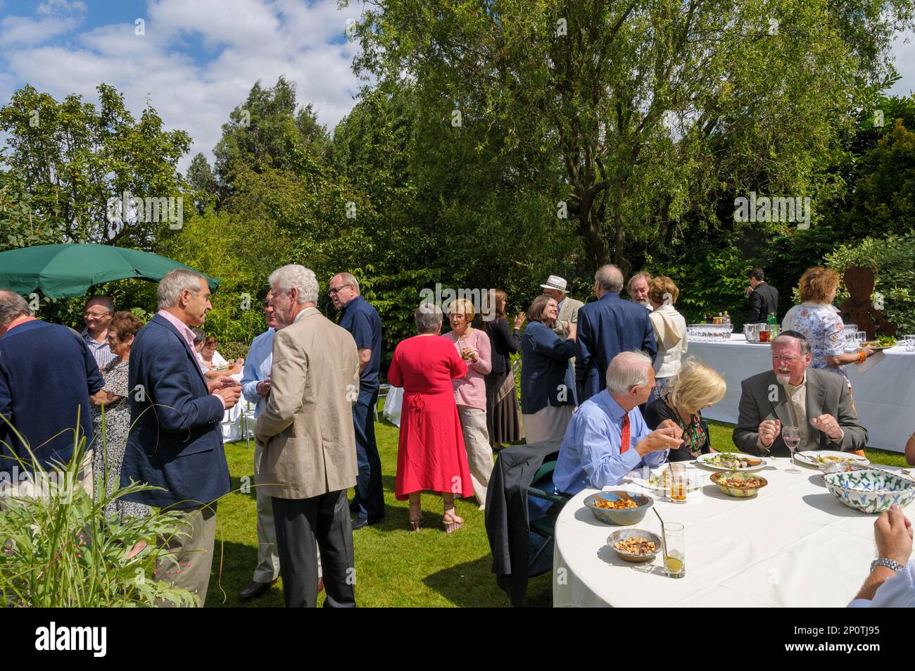 Gente de clase media socializando en una fiesta en el jardín, Londres, Inglaterra, Reino Unido Foto de stock