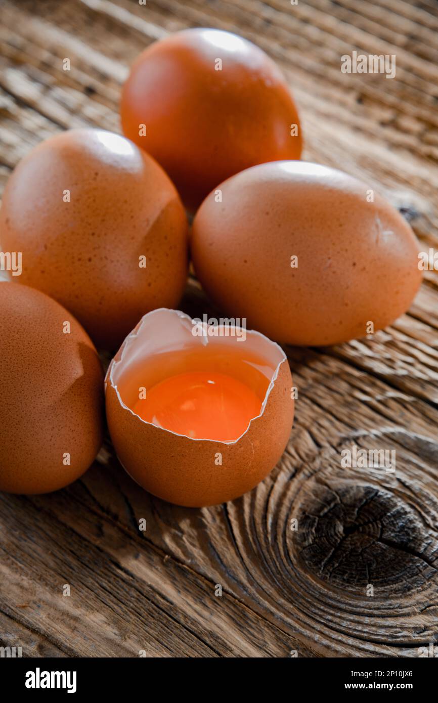 Composición con cinco huevos de pollo sobre una mesa de madera. Foto de stock