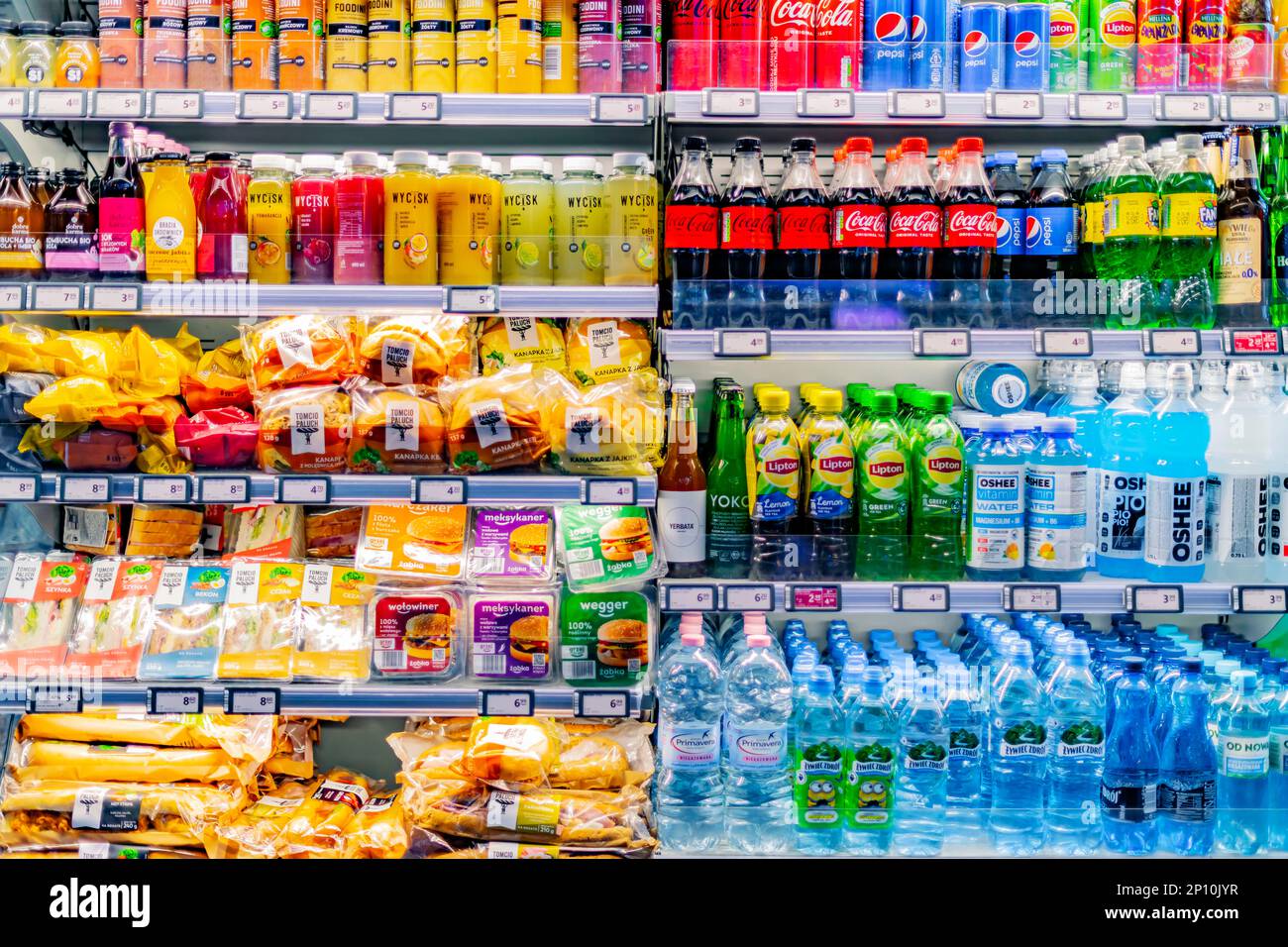 POZNAN, POL - MAR 12, 2022: Comida y bebidas pre-envasadas exhibidas en un refrigerador comercial en una tienda de conveniencia Foto de stock