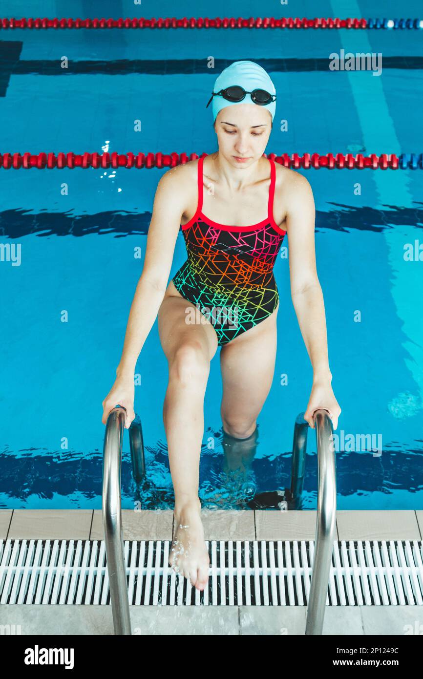 Mujer de natación muscular feliz en gafas y gorra en la piscina y  representa el concepto de salud y buena forma. Modelo femenino hermoso en  el agua Fotografía de stock - Alamy